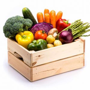 Pine box full of colorful fresh vegetables on a white background