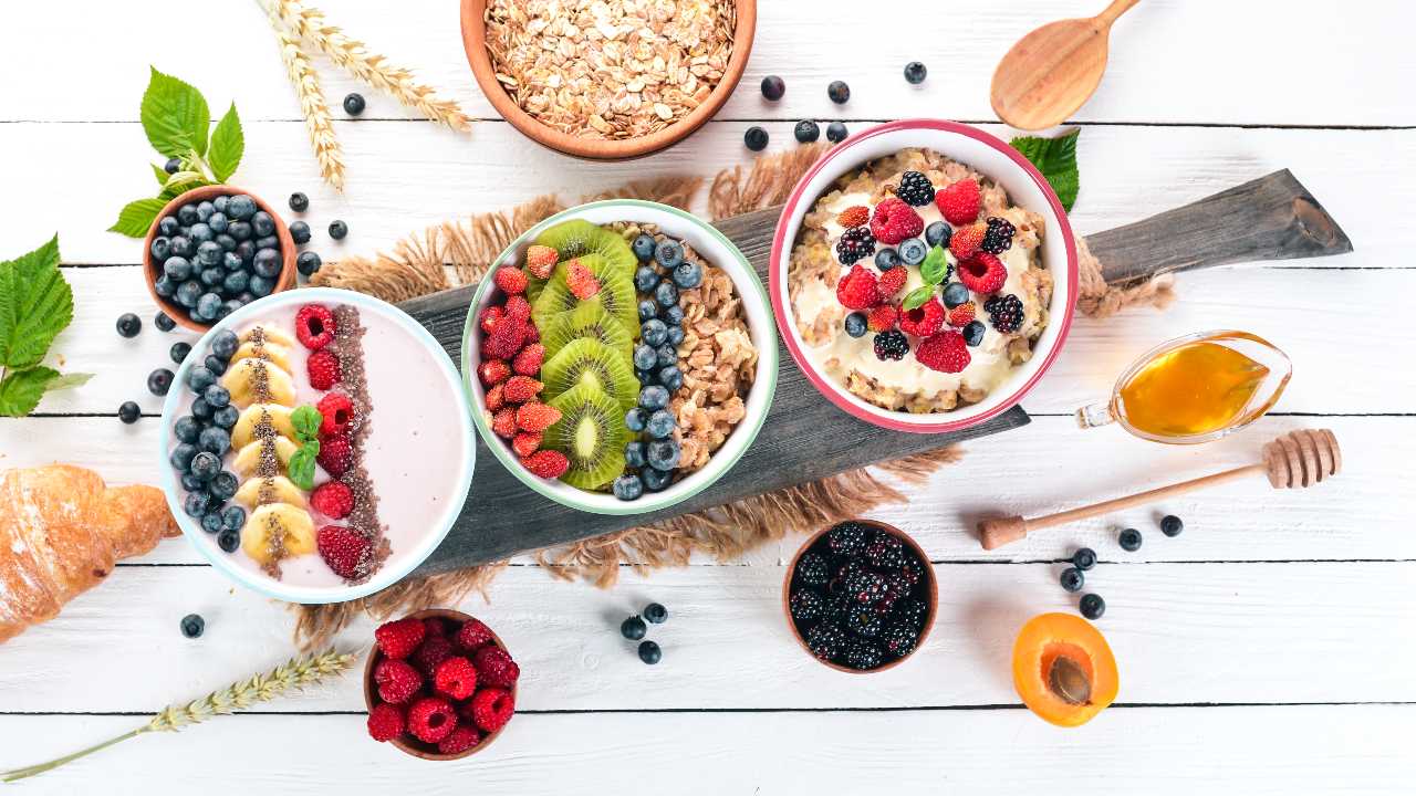 Large Assortment of porridge with fruit and berries. Breakfast. On a white wooden background. Top view. Free space for text Large Assortment of porridge with fruit and berries. Breakfast. On a white wooden background. Top view. Free space for text